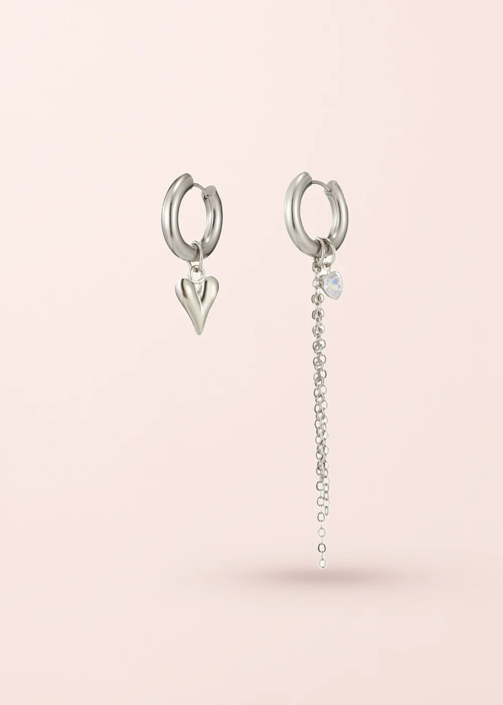 Belen Heart Asymetric Silver Earrings on a pink background