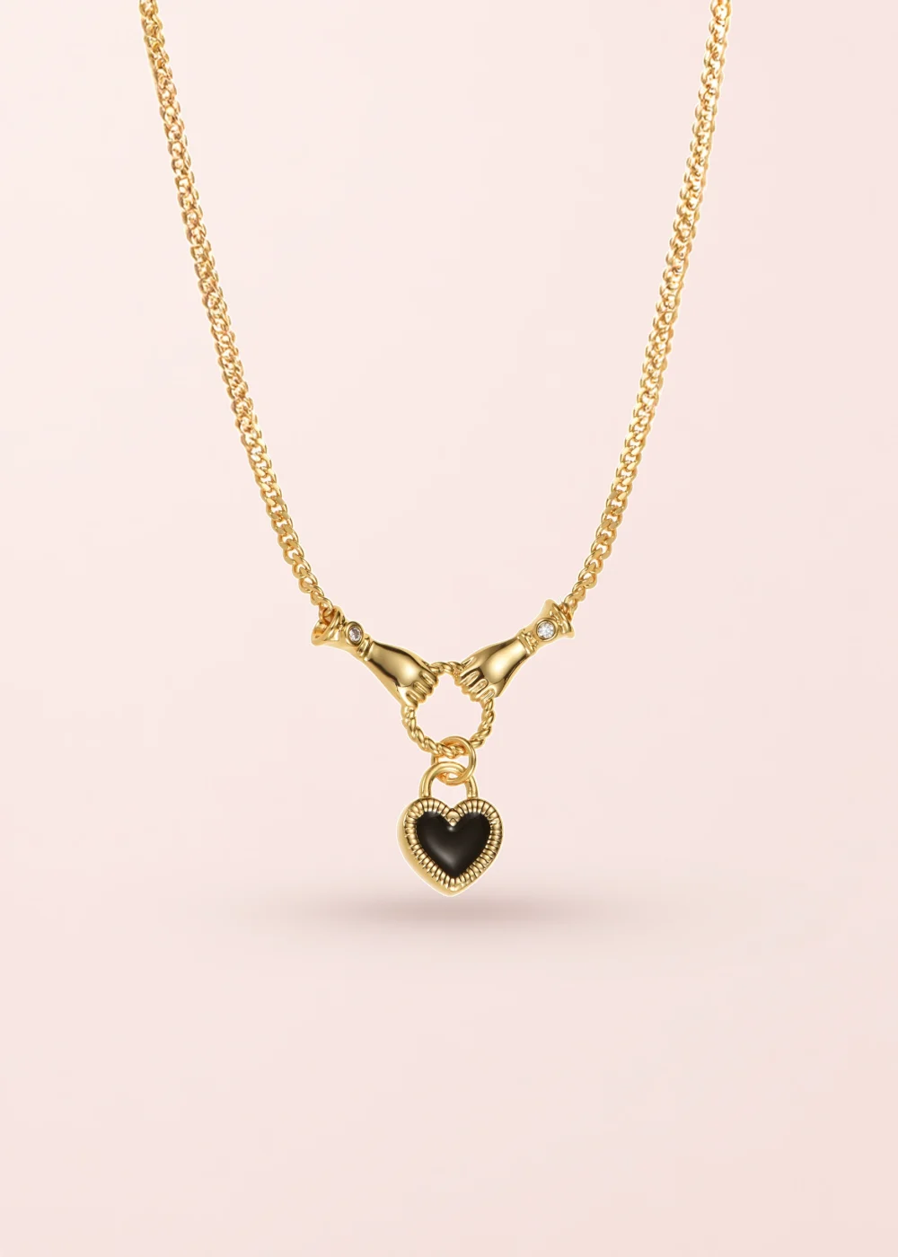 Madelaine Heart In Hands Love Golden Necklace on a pink background